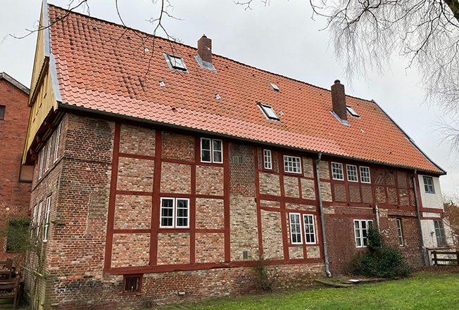 Seitansicht des alten Fachwerkhauses mit roten Backstein und rotem Dach