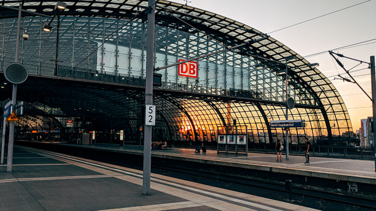 Bahngleise und Bahnsteig am Berliner Hauptbahnhof bei Sonnenuntergang